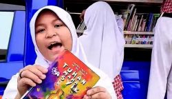 Salah seorang murid SD 011 Bontang Selatan memanfaatkan Perpustakaan Keliling milik Dinas Perpustakaan dan Kearsipan Kota Bontang, membaca buku, Rabu (29/10/2025).