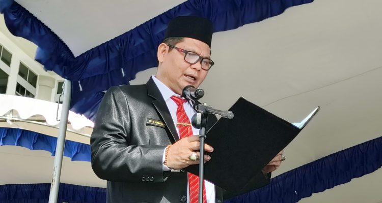 Kepala Dinsos Kutim, Ernata saat membacakan pesan Pahlawan Nasional di upacara peringatan Hari Pahlawan ke-80 tahun 2025 di Lapangan Kantor Bupati Kutim.