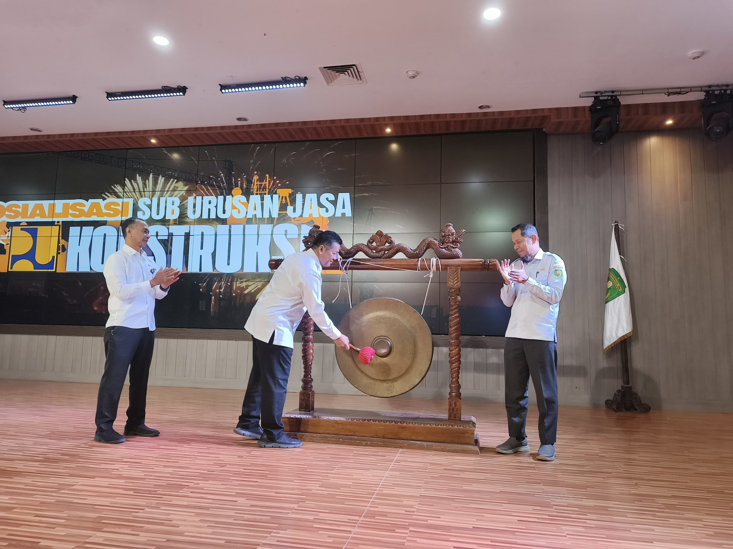 Asisten II Bidang Perekonomian dan Pembangunan Setkab Kutai Timur, Noviari Noor (tengah) memukul gong tanda dibukanya kegiatan Sosialisasi Sub Urusan Jasa Konstruksi. Didampingi Plt Kepala Dinas PUPR Kutim, Joni Abdi Setia (kanan).